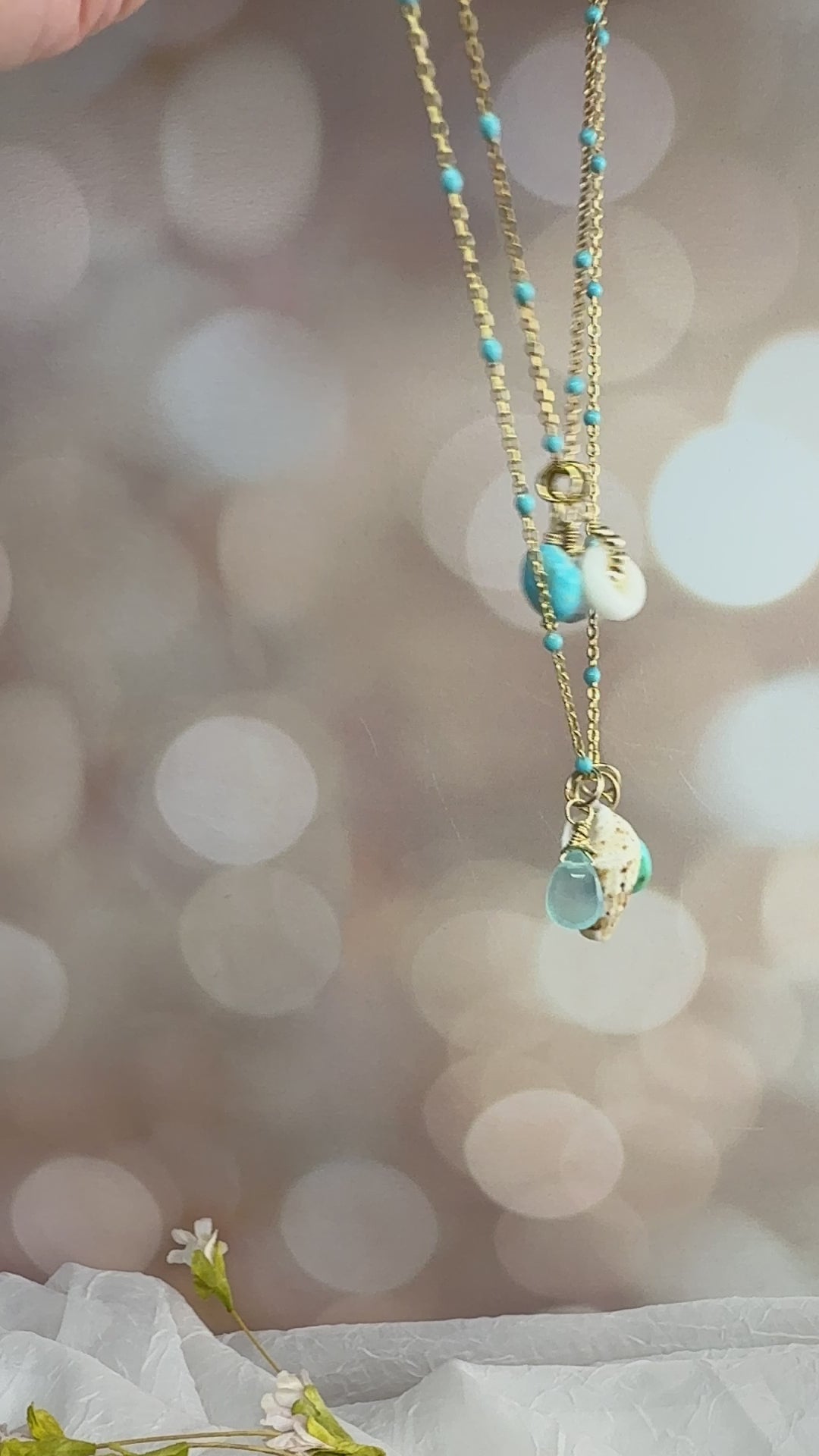Puka, shell, turquoise & Aquamarine charms on an enamel beaded chain. 